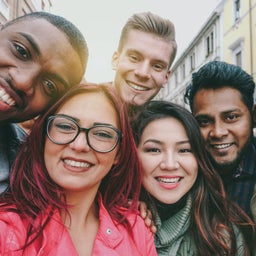 Happy friends from diverse cultures and races taking selfie with back lighting - Youth and friendship concept with young people having fun together